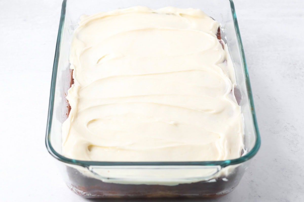 A frosted peaches and cream cake in a baking dish.