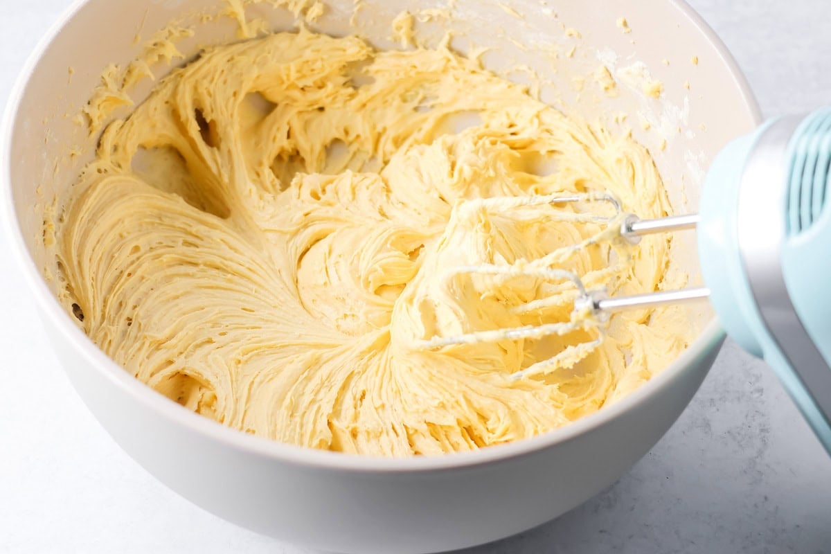 Mixing easy pineapple cake batter in a white bowl.