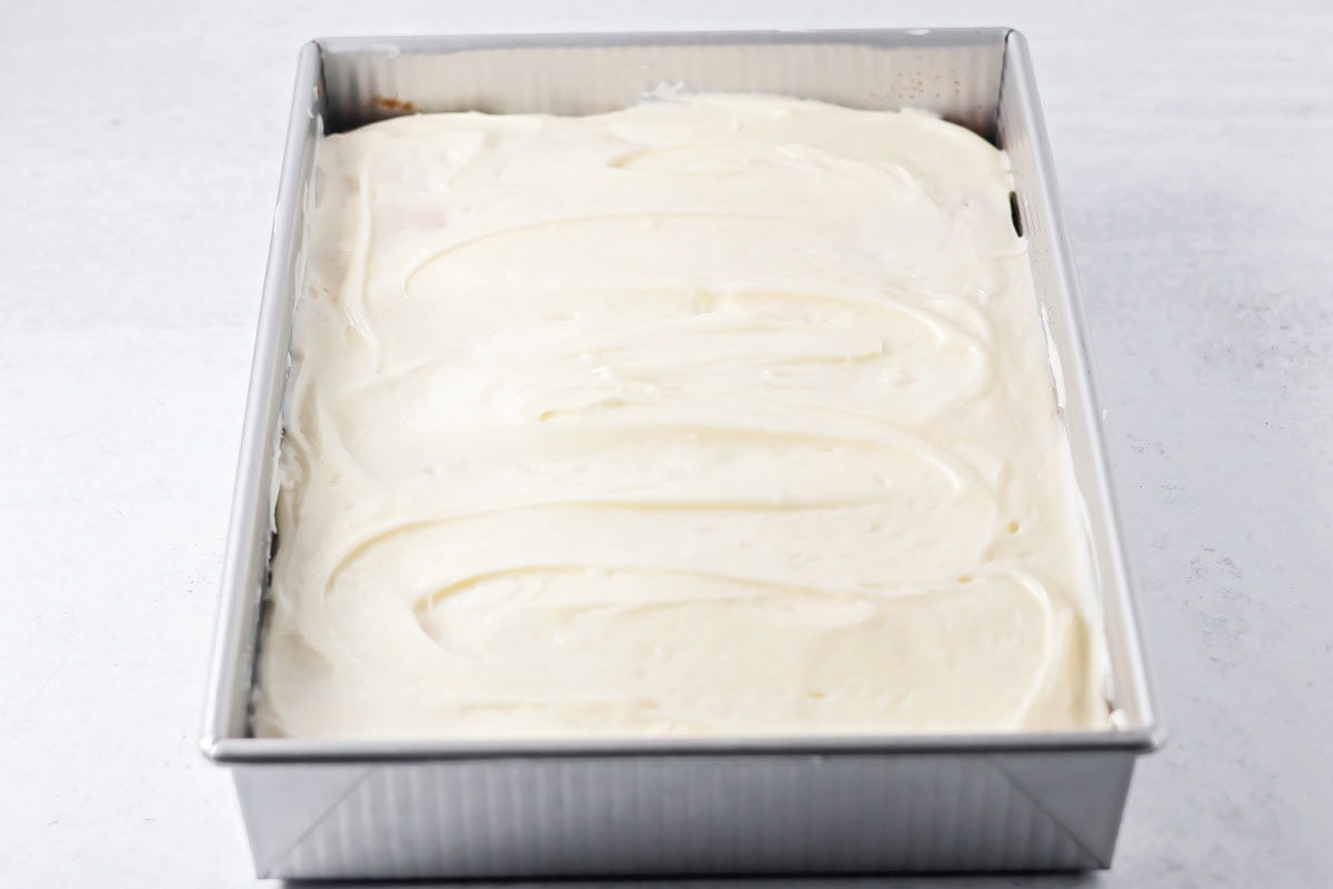 A frosted easy pineapple cake in a baking pan.