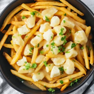 Poutine recipe in a black bowl.