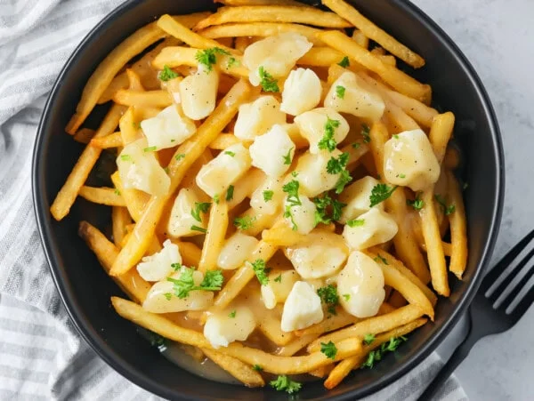 Poutine recipe in a black bowl.