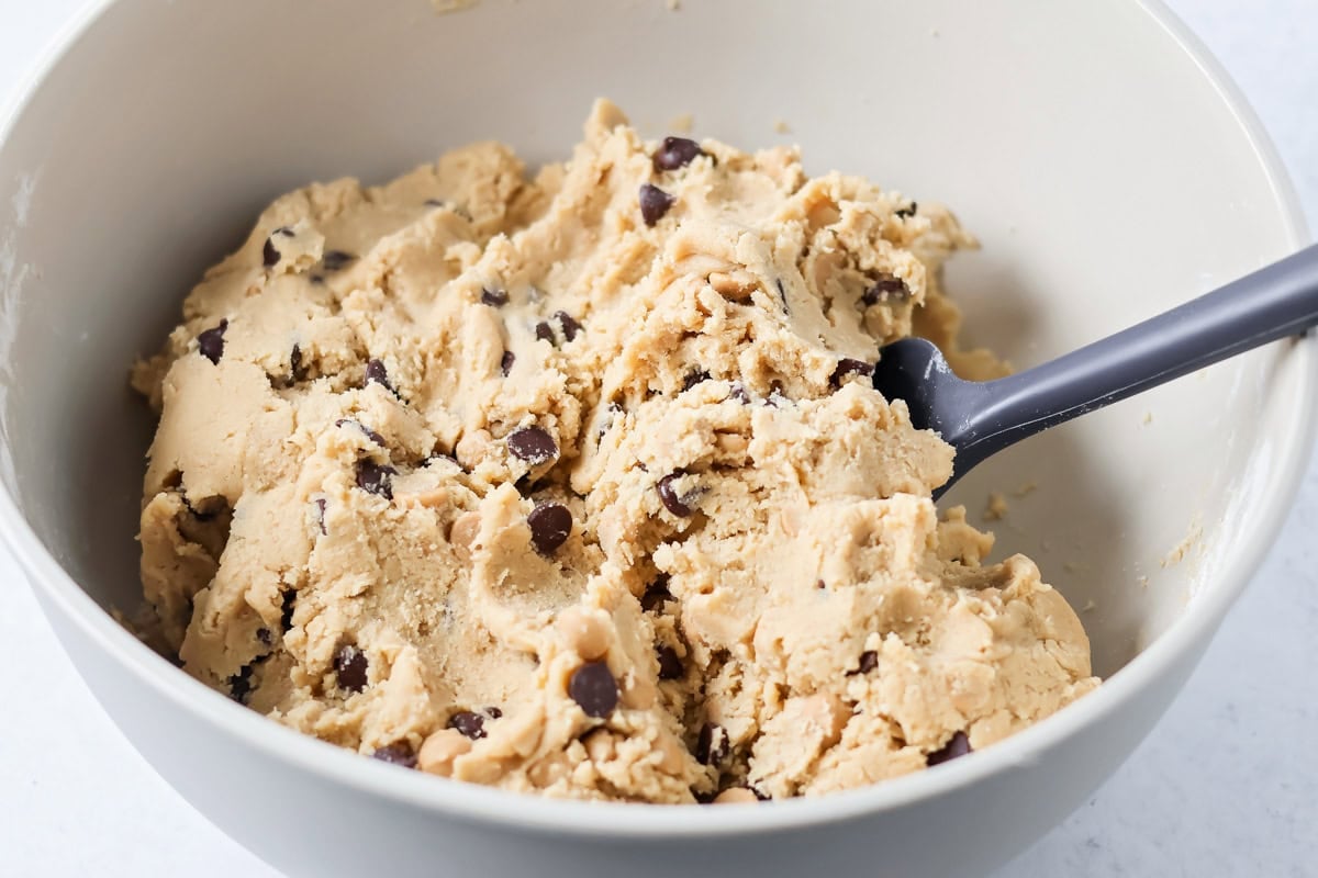 Salted caramel chocolate chip cookie dough mixed together in bowl.