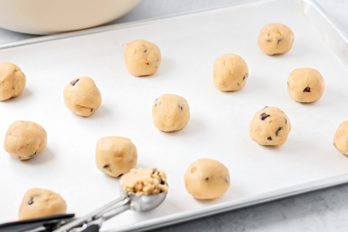 Salted caramel chocolate chip cookie dough balls on cookie sheet.