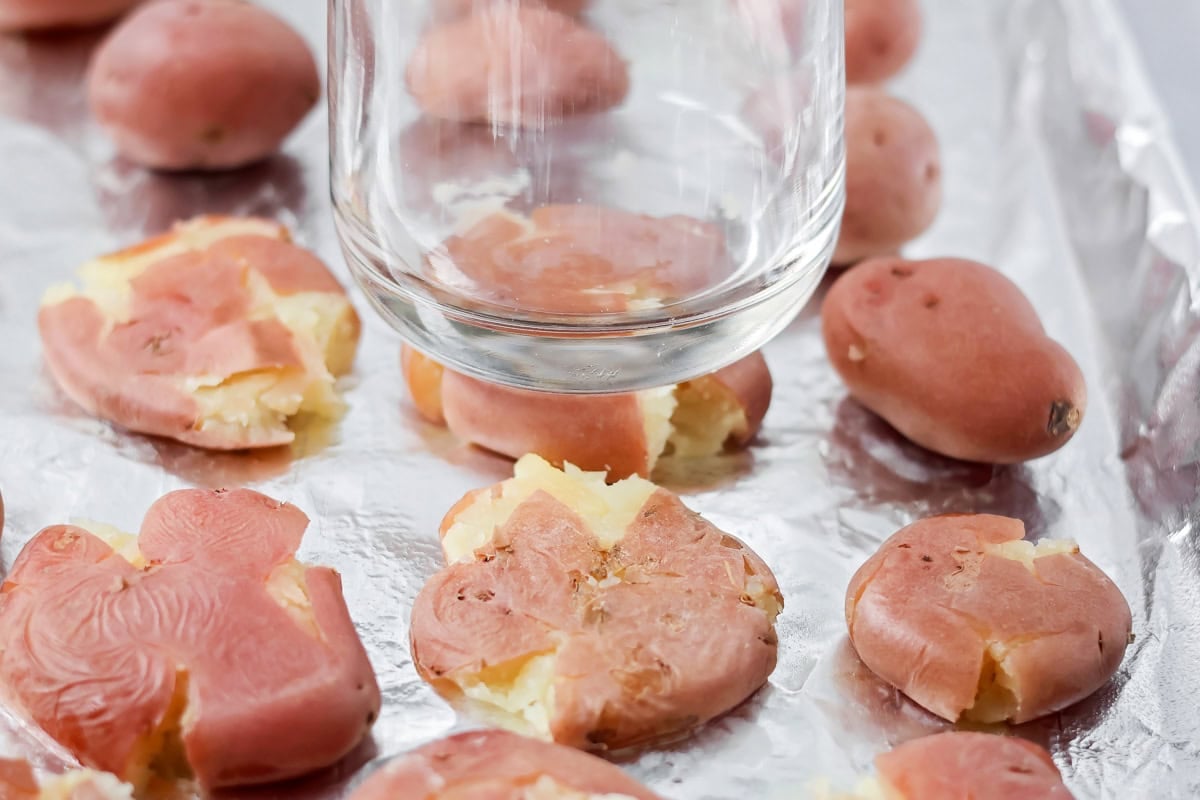Red potatoes being smashed by a jar.