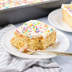 A slice of sugar cookie cake topped with frosting and sprinkles.