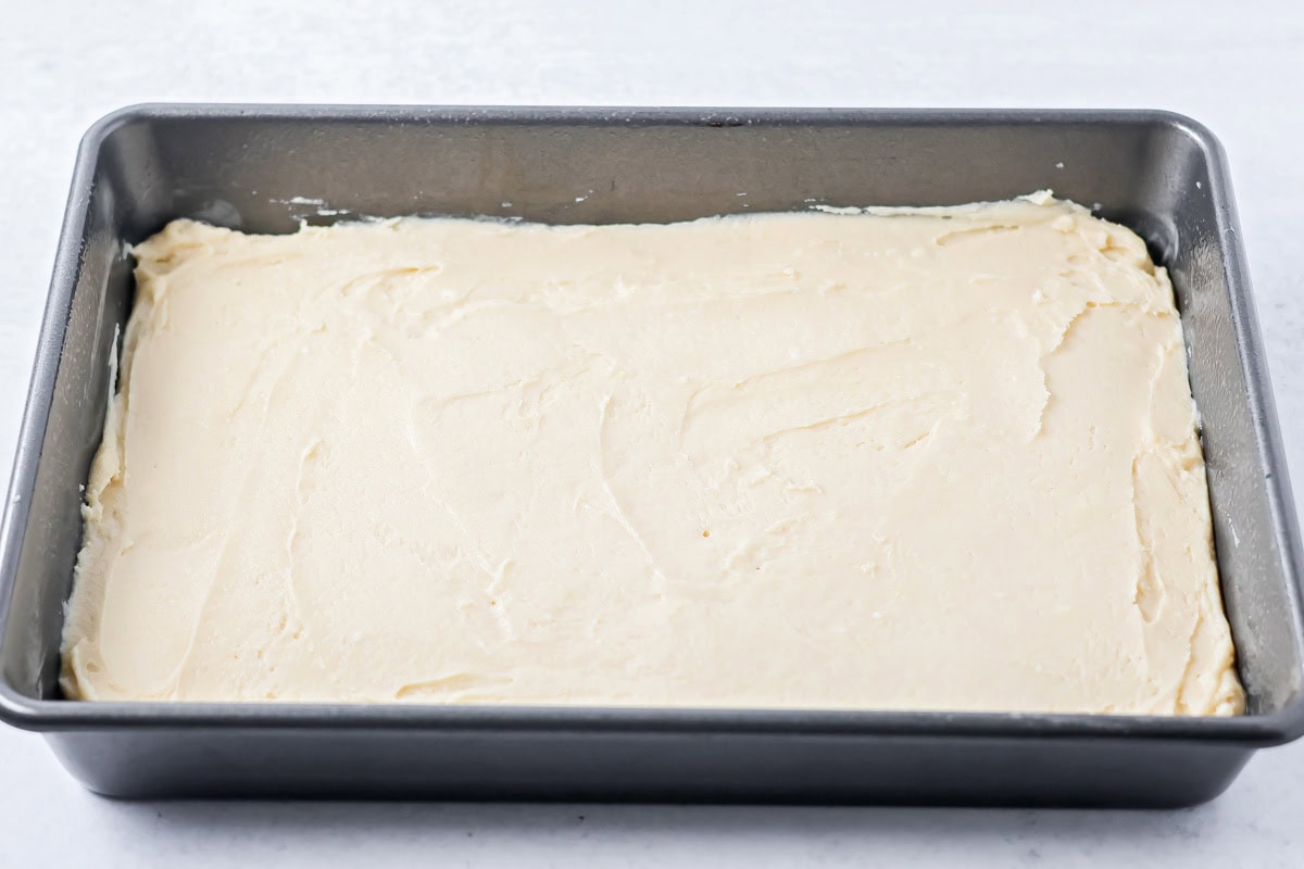 Spreading sugar cookie batter in a baking dish.