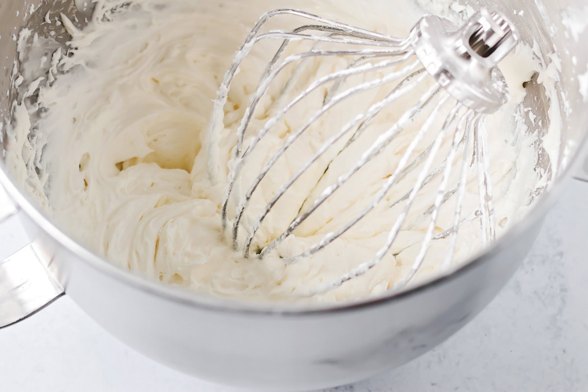 Whisking sugar cookie frosting in a bowl.