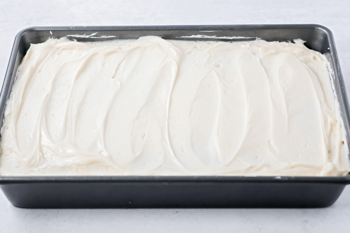 A sugar cookie cake topped with white frosting.