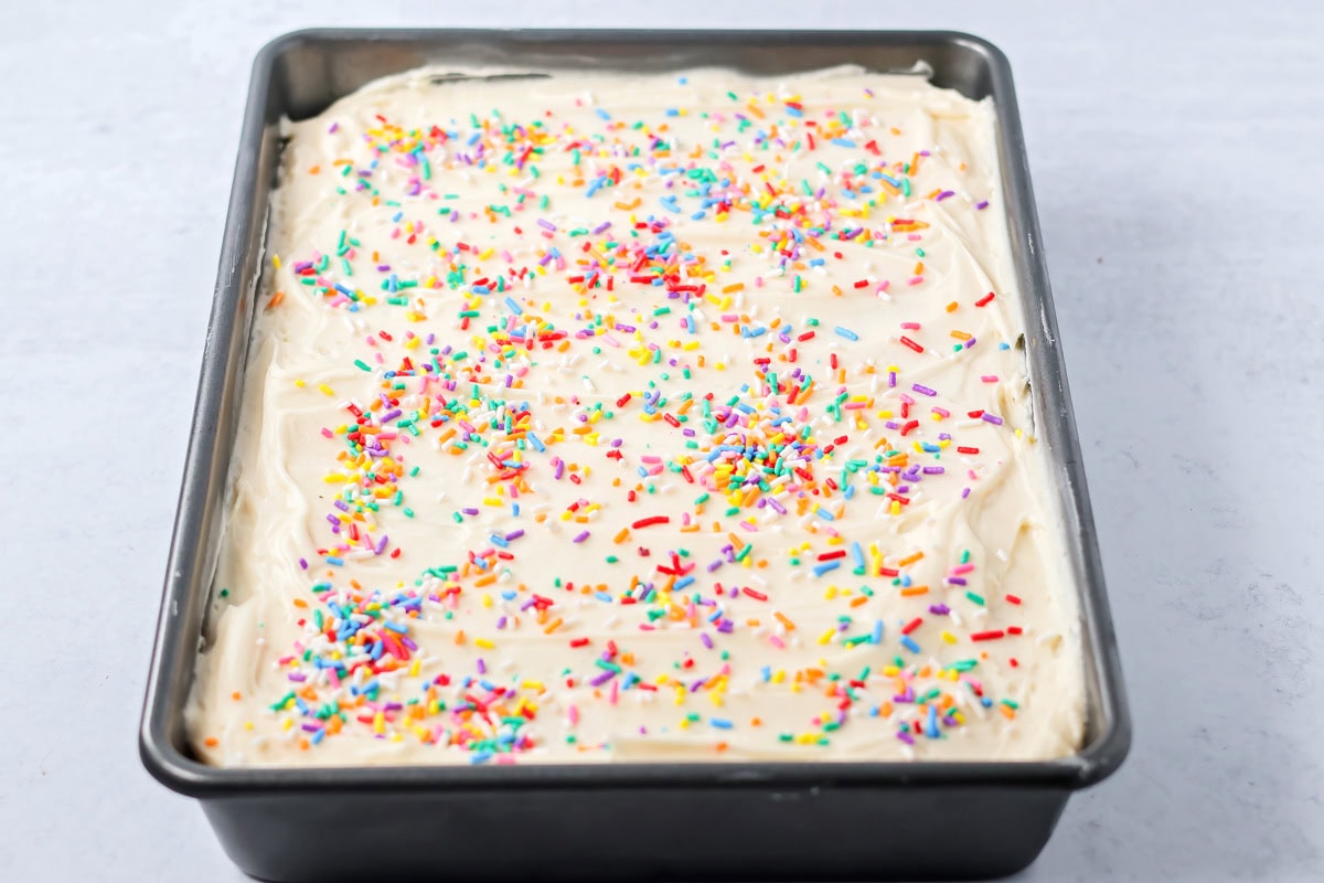 A frosted sugar cookie cake topped with sprinkles.