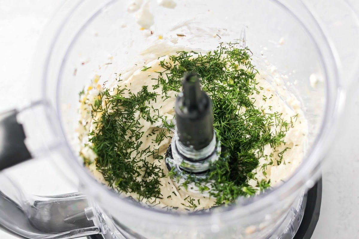 Whipped feta in a blender with fresh herbs.