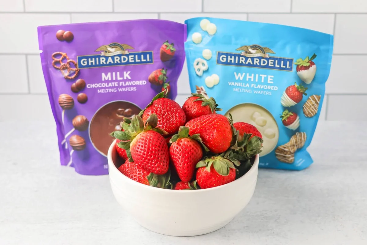 Create everyone's favorite treat at home with this simple and quick tutorial for how to make chocolate covered strawberries! Chocolate Covered strawberries ingredients on counter.