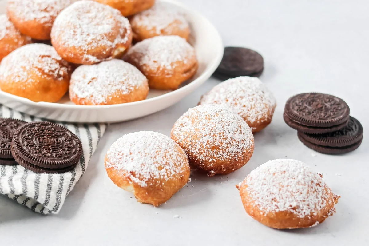 Fried Oreos dusted in powdered sugar with Oreos on the side.