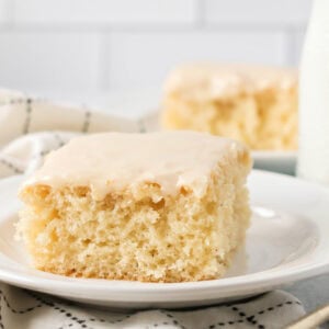 Buttermilk cake slice glazed and served on a white plate.