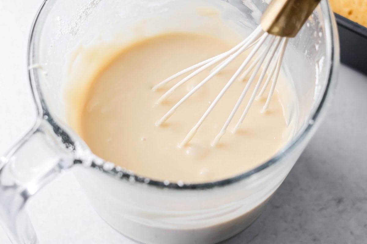 Whisking buttermilk cake glaze in a glass measuring bowl.
