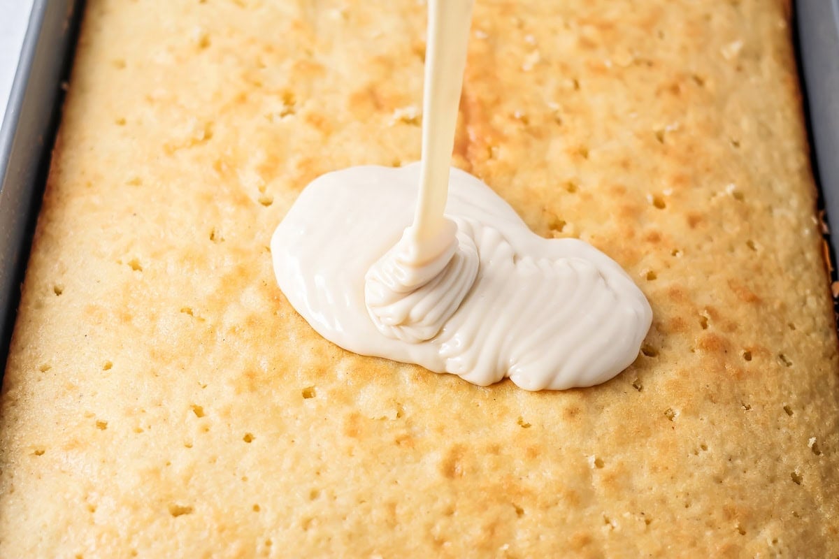 Pouring glaze over baked buttermilk cake.