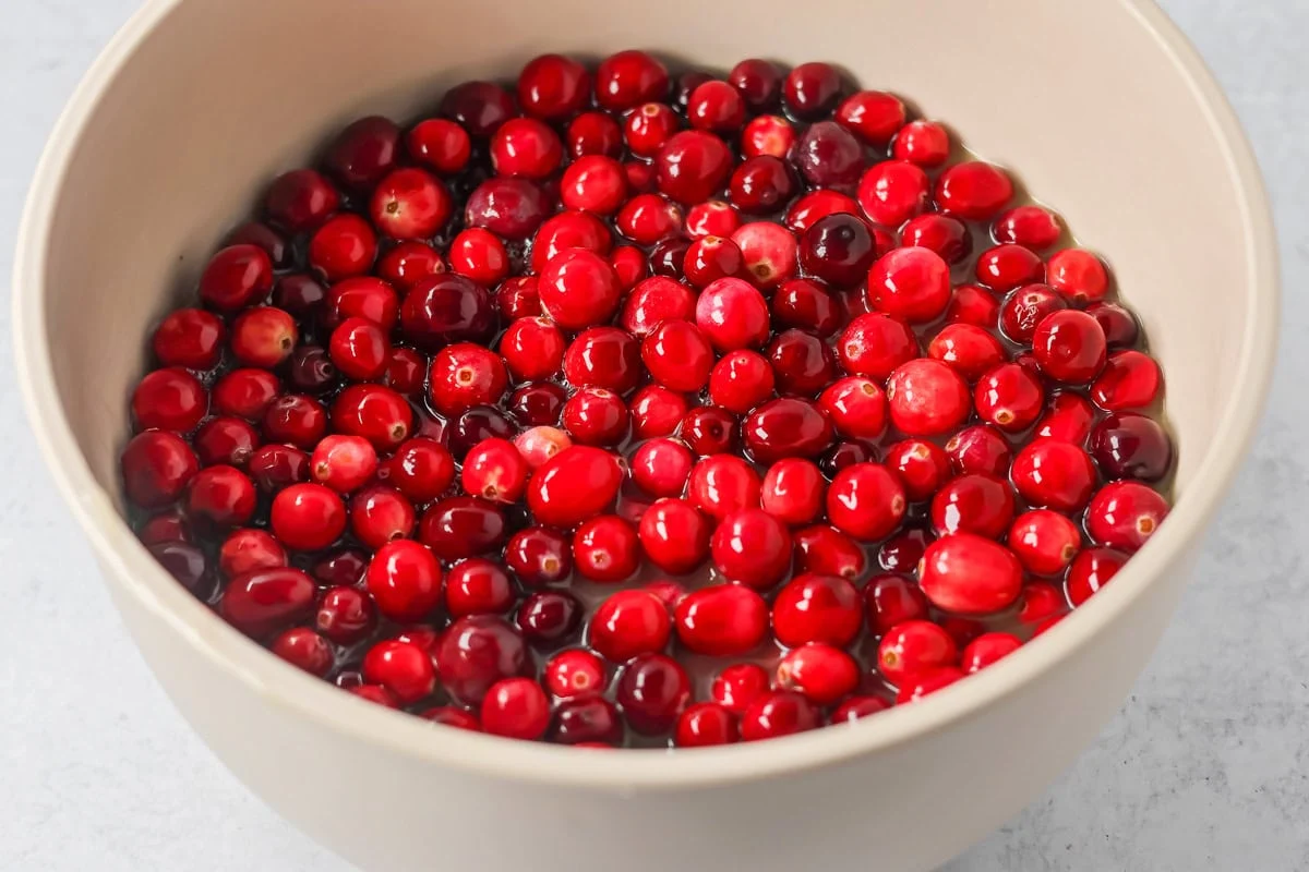 A bowl of cranberries in sprite for making candied cranberries.