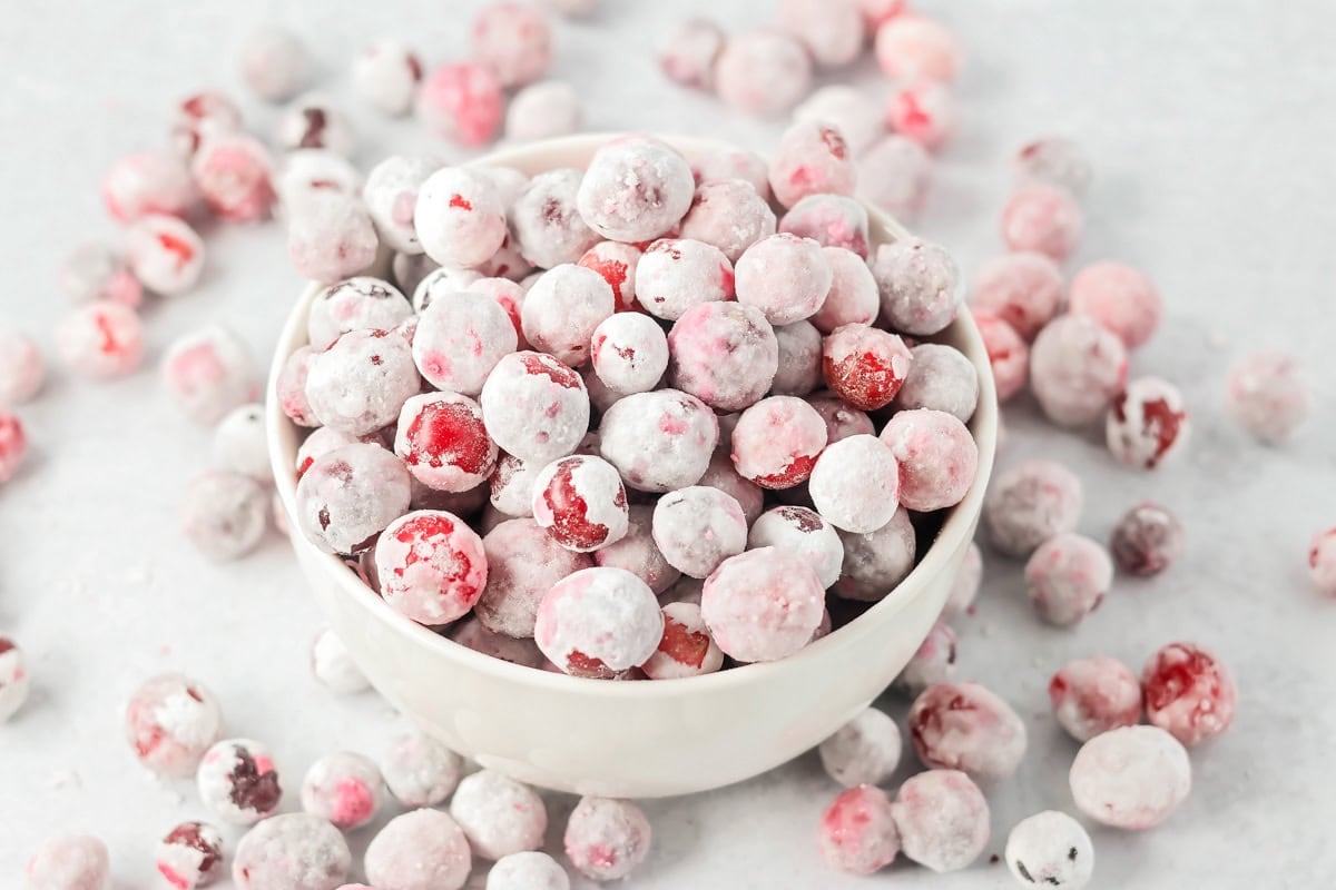 Candied cranberries in a white bowl.