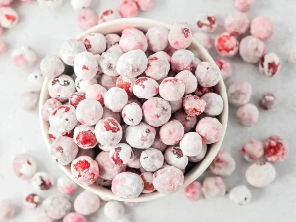 Candied cranberries in a white bowl.
