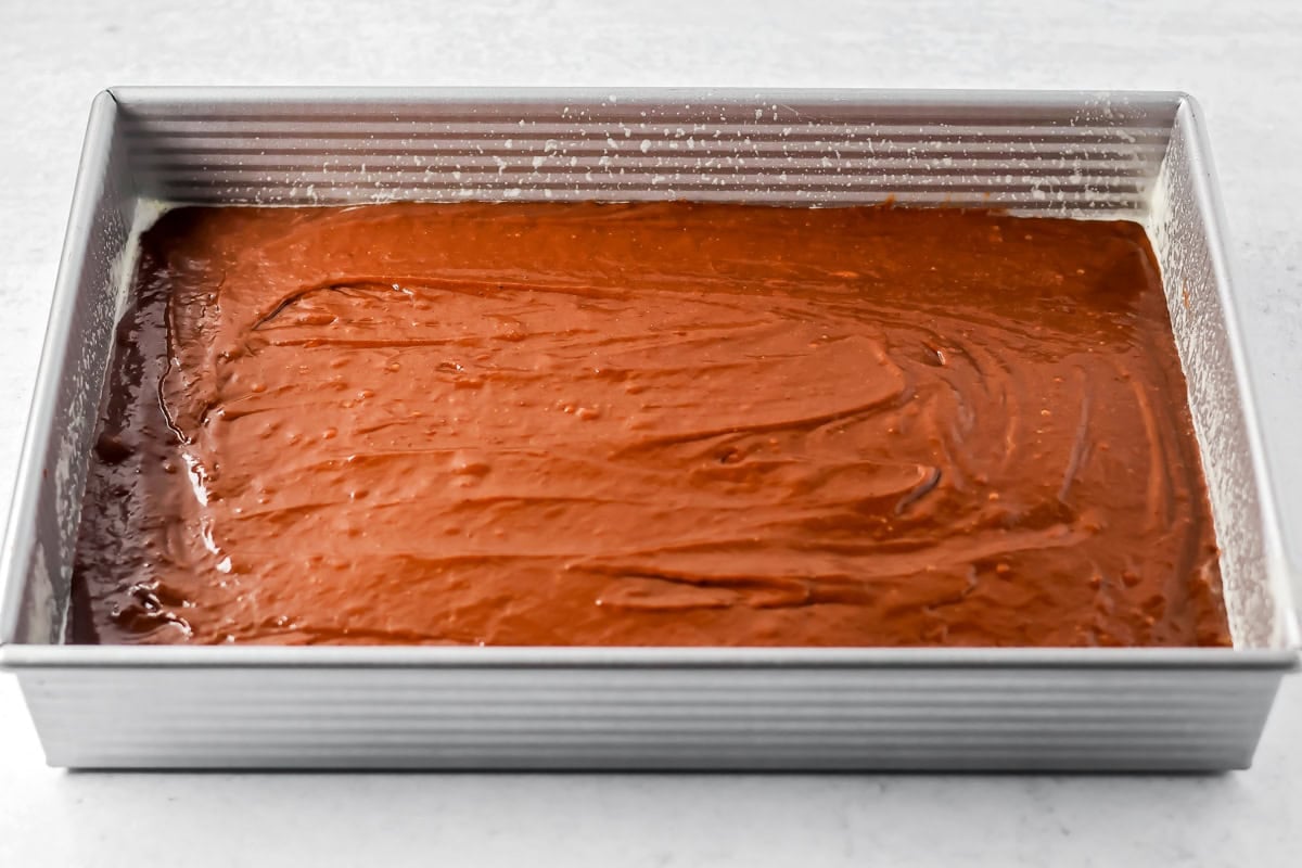 Chocolate pumpkin cake batter spread in a baking dish.