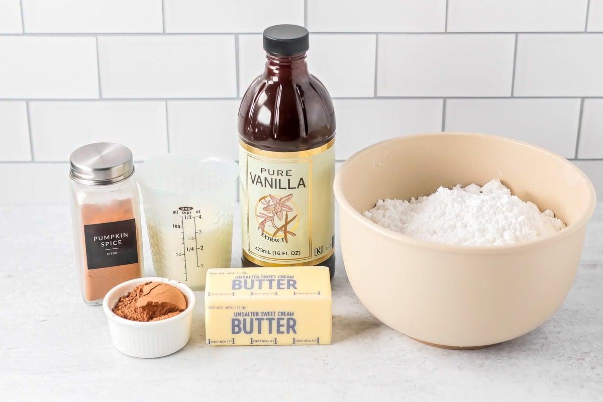 Ingredients for chocolate pumpkin cake frosting on a kitchen counter.