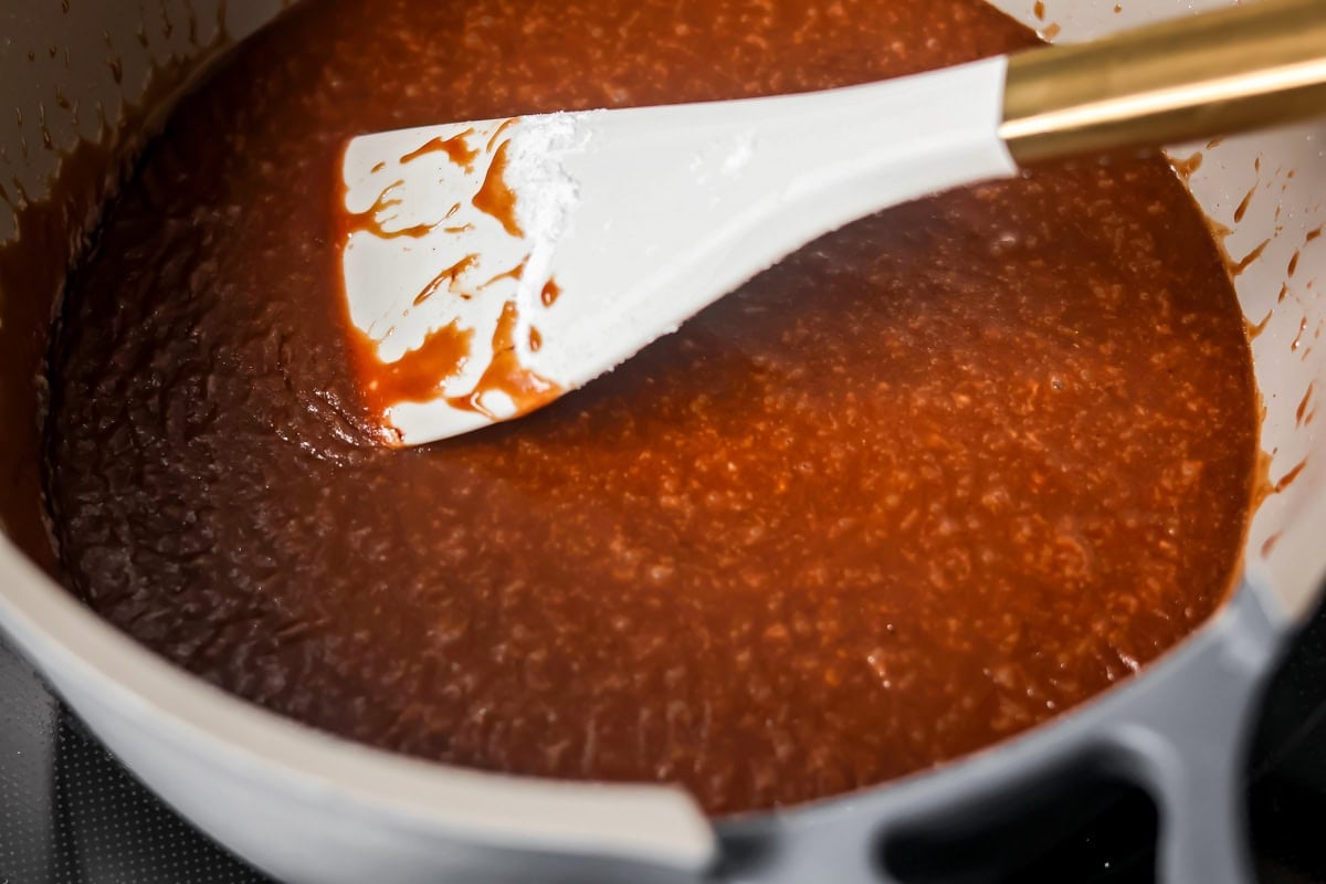 Stirring frosting in a bowl for chocolate pumpkin cake.