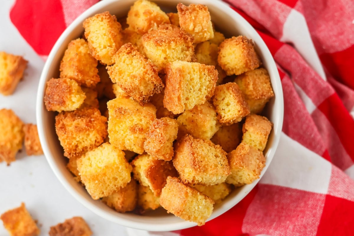 A white bowl filled with cornbread croutons.