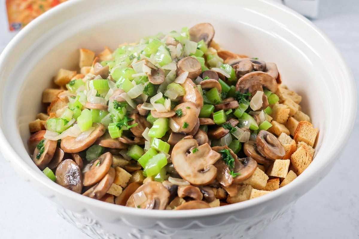 Adding veggies to bread for crock pot stuffing.
