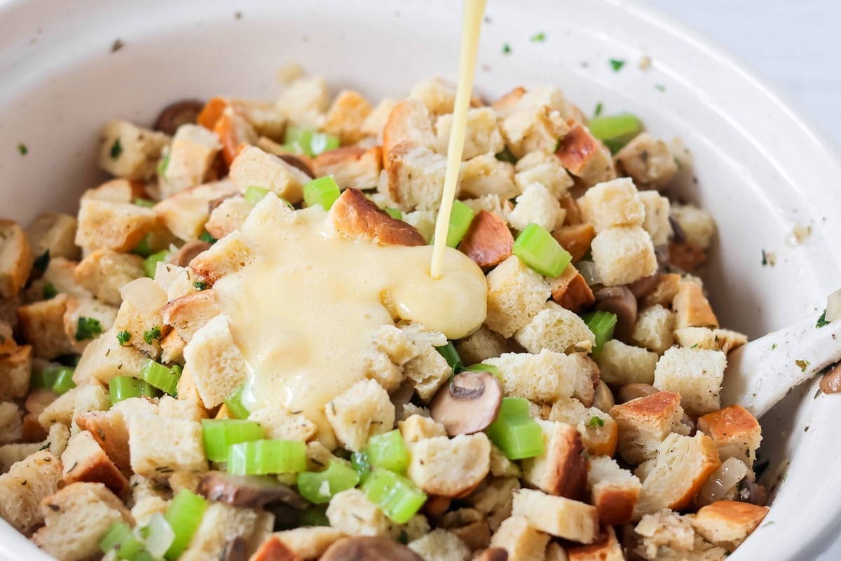 Adding gravy to crock pot stuffing.