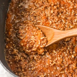 Scooping a serving of crock pot sweet potato casserole.