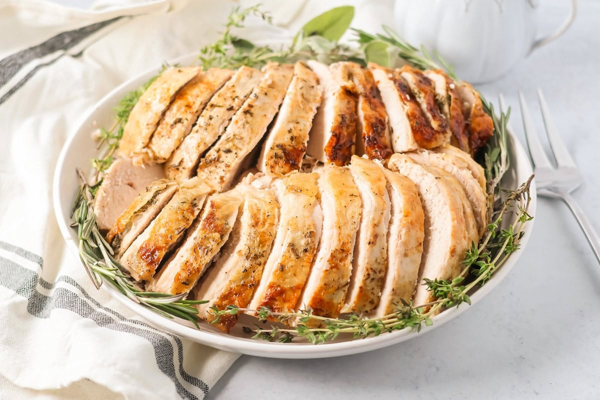 Sliced crock pot turkey on a platter.