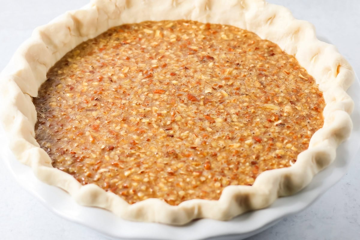 Custard pecan filling in an unbaked pie crust.