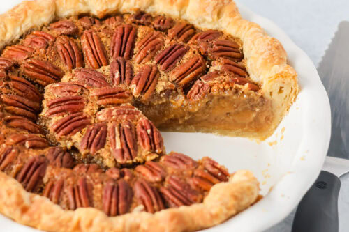 Custard pecan pie with a slice missing.