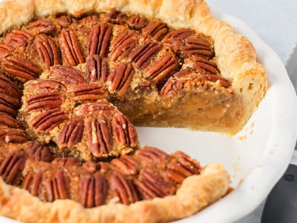 Custard pecan pie with a slice missing.