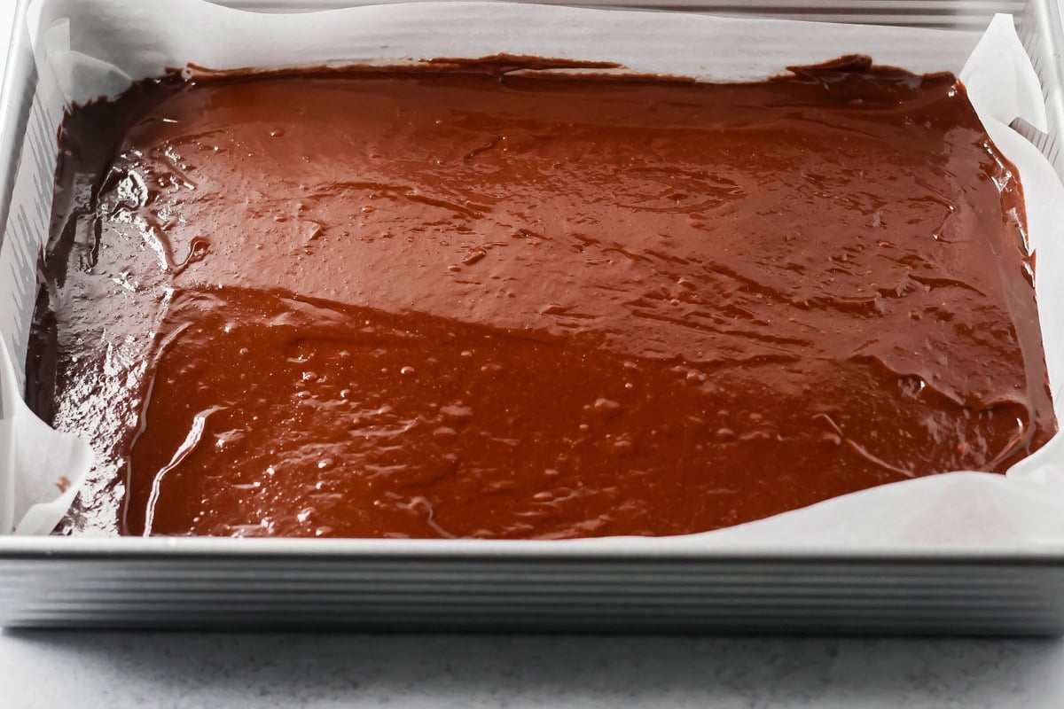Brownie batter in a baking dish for making pecan pie brownies.