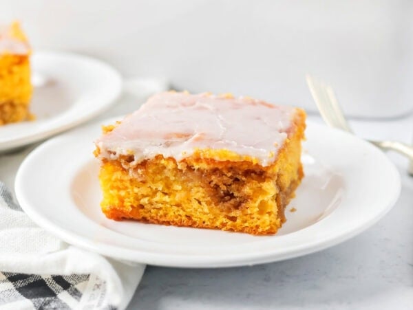 A slice of pumpkin honey bun cake on a white plate.