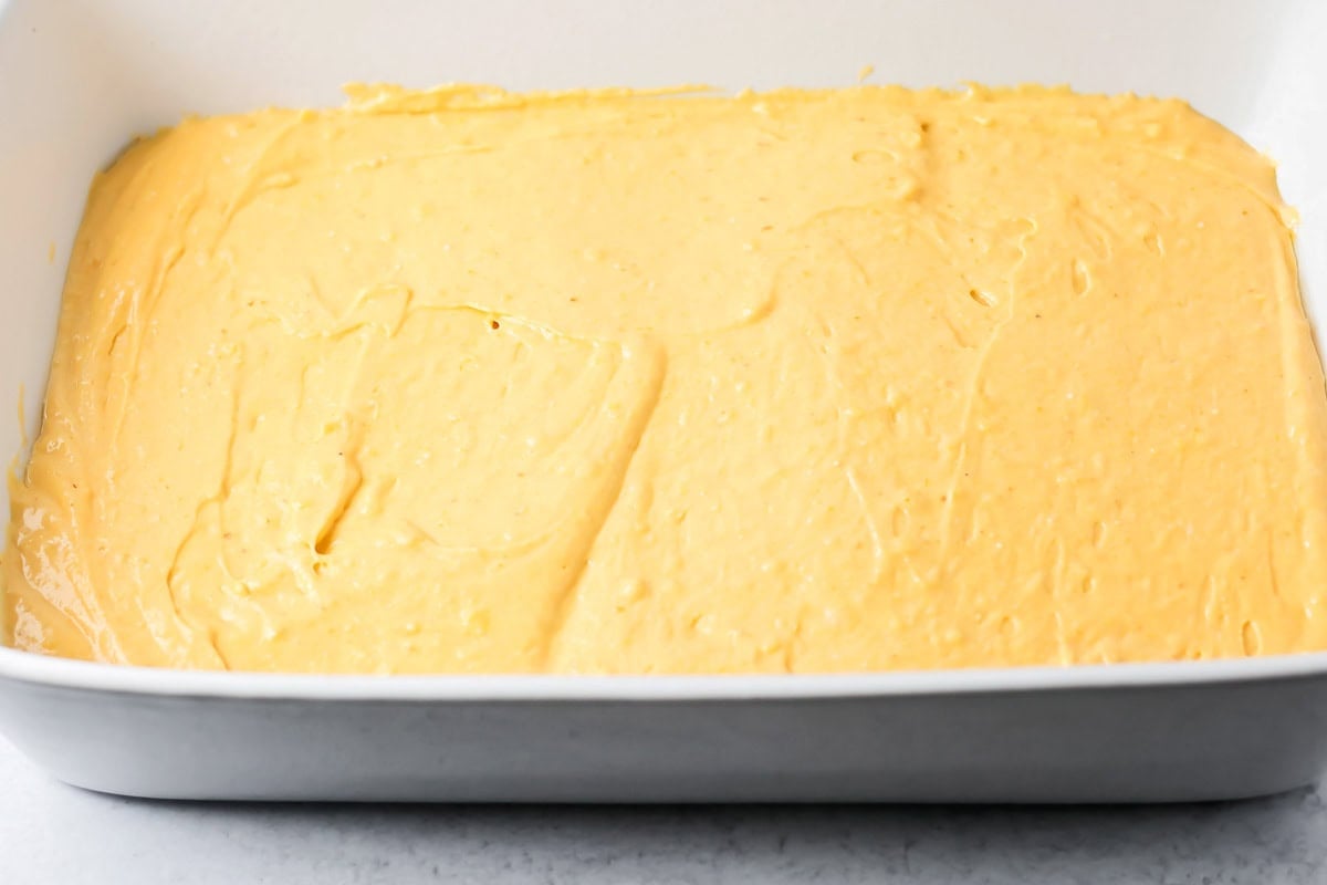 The first layer of pumpkin honey bun cake batter in a baking dish.