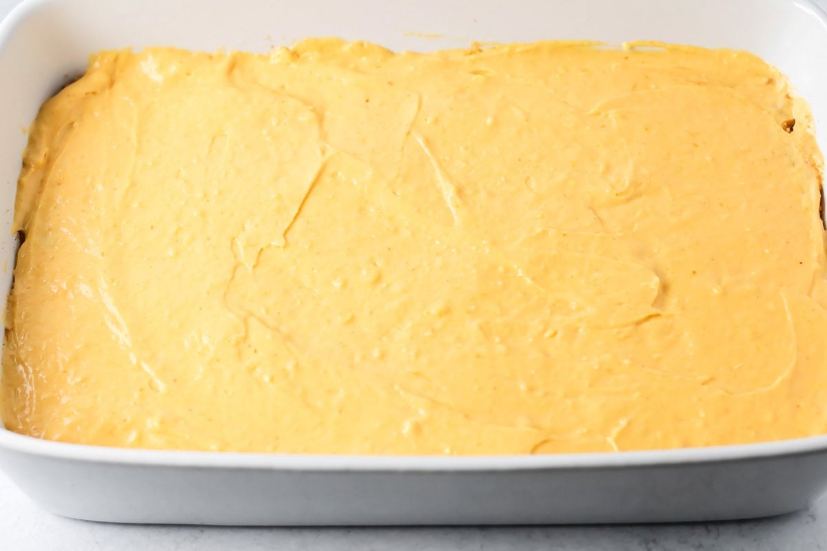 Pumpkin honey bun cake batter in a white baking dish.