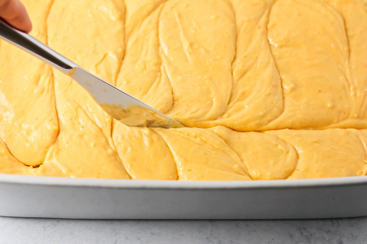 Swirling pumpkin honey bun cake with a knife.