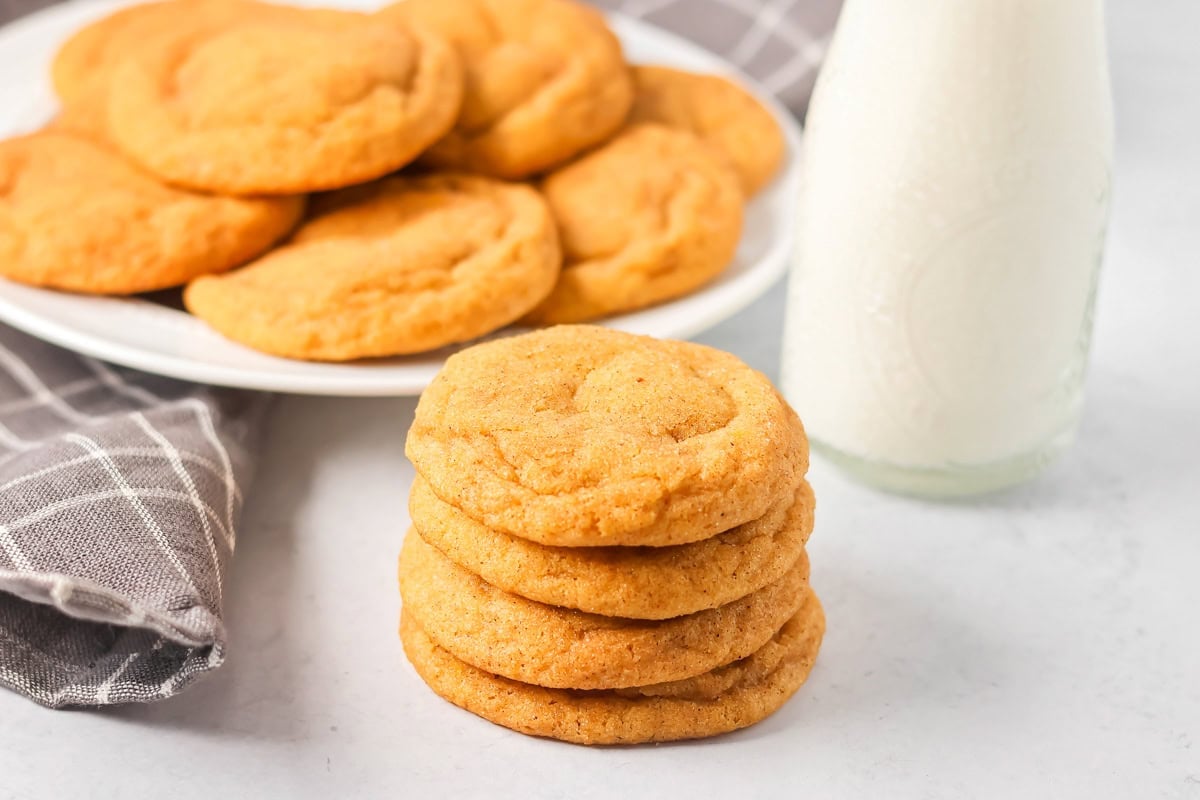 Stacked pumpkin snickerdoodles served with milk.