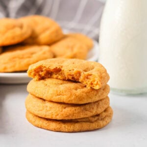 Pumpkin snickerdoodles stacked with a bit missing from the top one.