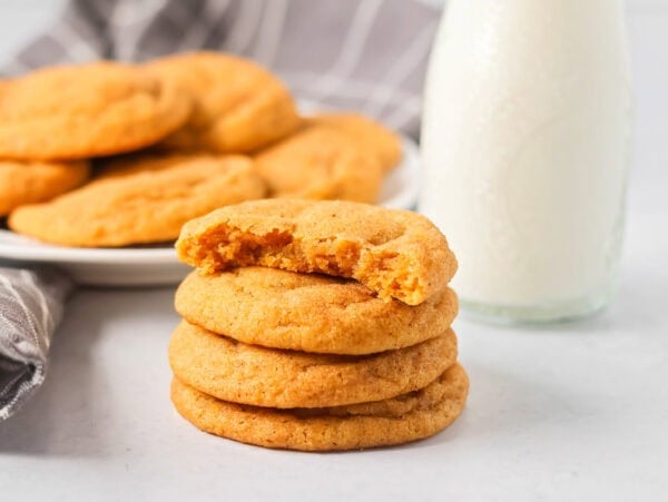 Pumpkin snickerdoodles stacked with a bit missing from the top one.