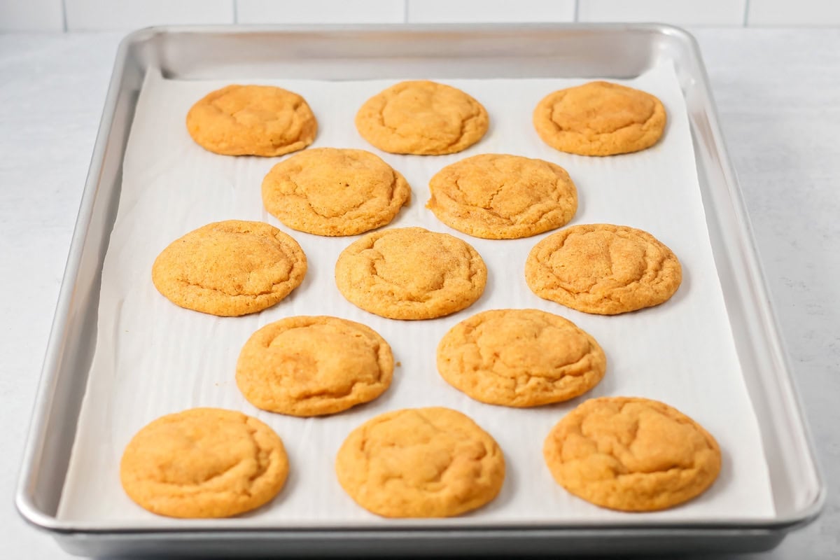 Baked pumpkin snickerdoodles on a sheet pan.