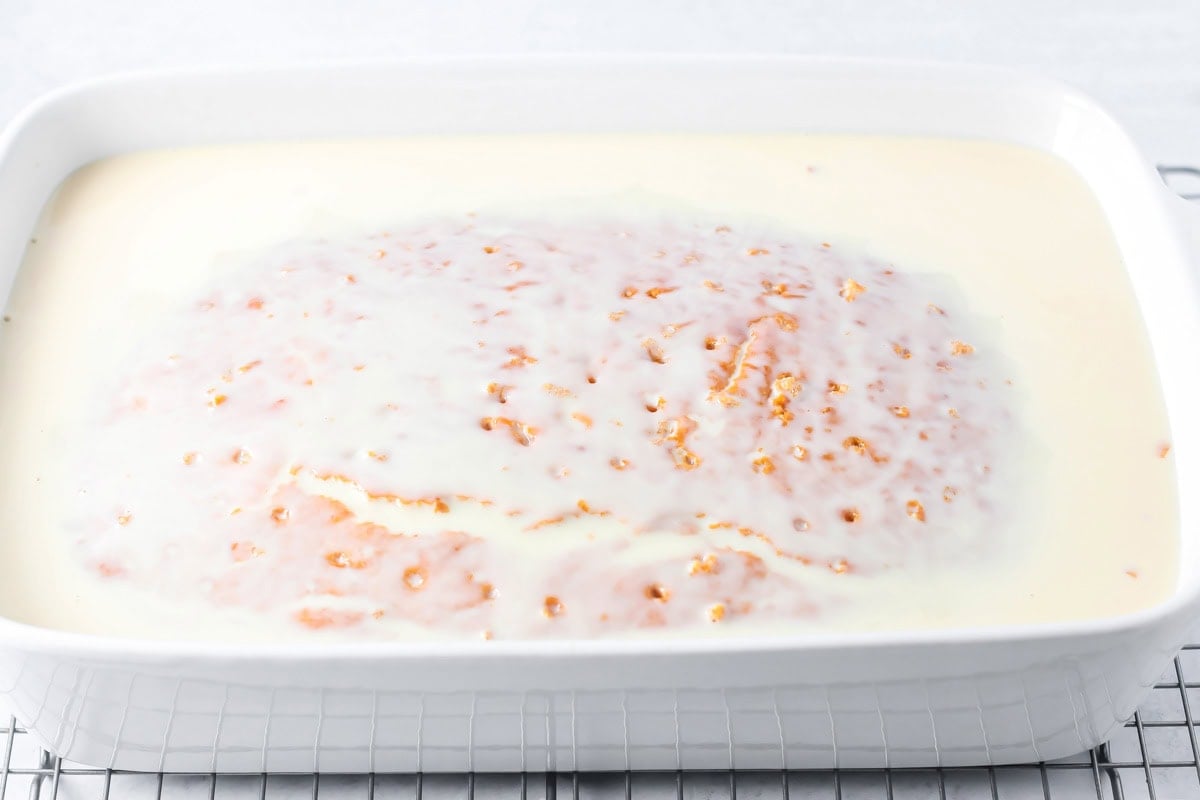 Adding milk to the top of a pumpkin tres leches cake.