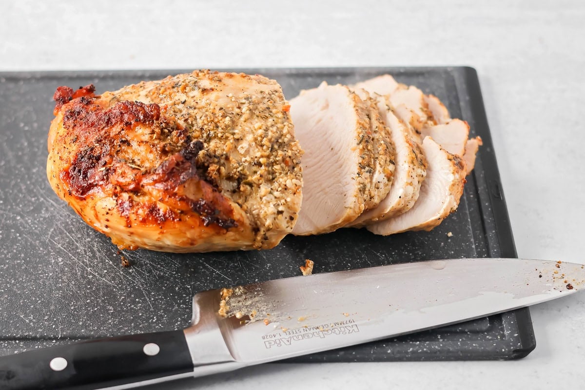 Slicing roast turkey breast on a cutting board.
