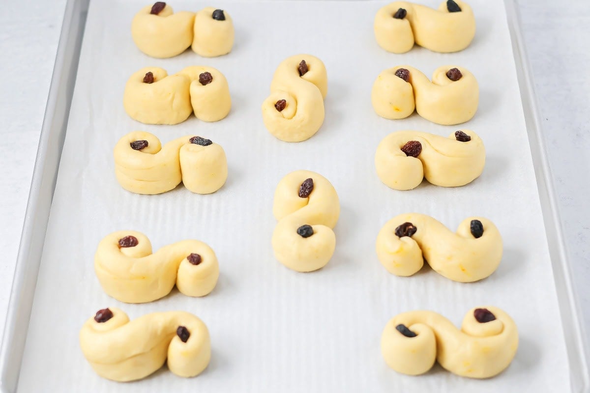 St. Lucia Buns topped with raisins and ready to be brushed.