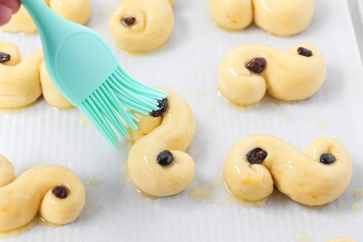 Brushing St. Lucia Buns before baking.