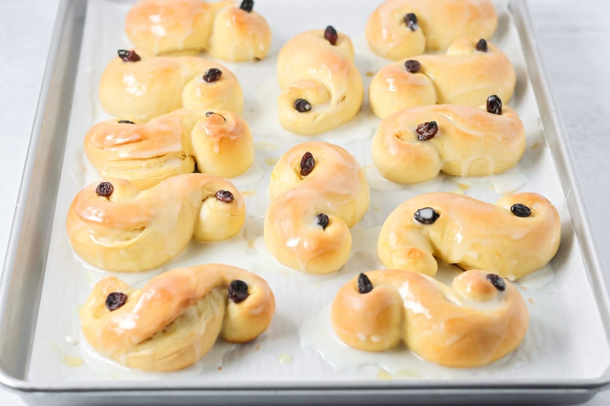 St. Lucia Buns glazed on a baking sheet.