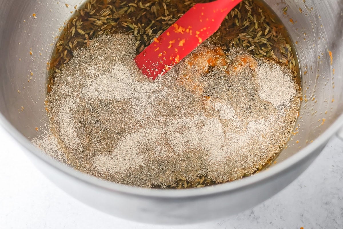 Adding spices to a bowl for making Swedish limpa bread.
