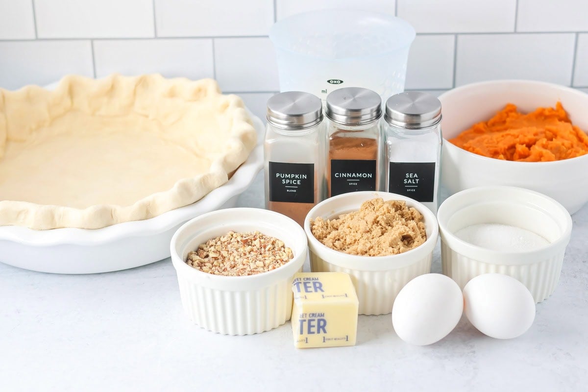 Ingredients for sweet potato pecan pie on a kitchen counter.