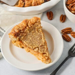 A slice of sweet potato pecan pie on a white plate.